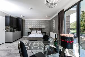 a living room with a bed and a glass table at ICON APARTMENTS in Gdańsk +41 photos