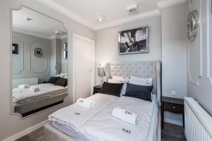 a bedroom with two beds and a mirror at ICON APARTMENTS in Gdańsk