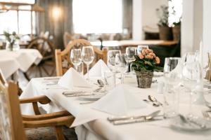 - une table avec des verres, des serviettes et des fleurs dans l'établissement Sporthotel by Alpenlodge, à Brand