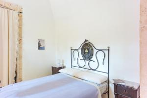 1 dormitorio con 1 cama con cabecero de hierro forjado en Depéndance en Polignano a Mare