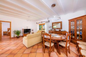 a dining room and living room with a table and chairs at Ca Na Rosa in Alcudia