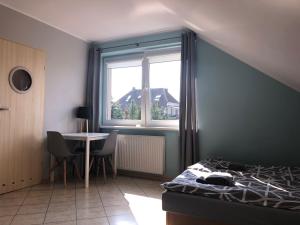 une chambre avec un lit, une table et une fenêtre dans l'établissement Kwatery prywatne pokoje i apartament JOANNA w Grzybowie, à Grzybowo