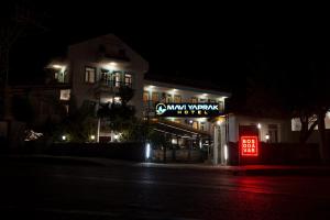 a building with a neon sign at night at Mavi Yaprak Hotel in Oludeniz