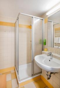 y baño con lavabo y ducha. en JUFA Hotel Vulkanland, en Gnas