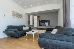 Una sala de estar con dos sofás y una mesa. en Villa Amaris, en Brodarica