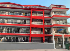 a red building with balconies on the side of it at M & M Red Luxury in Paralia Katerinis