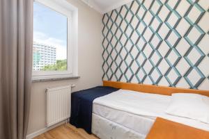 a small bedroom with a bed and a window at Jantar Apartamenty Sunny Olymp I in Kołobrzeg