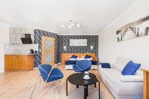 コウォブジェクにあるJantar Apartamenty Sunny Olymp Iのリビングルーム(白いソファ、青い椅子付)