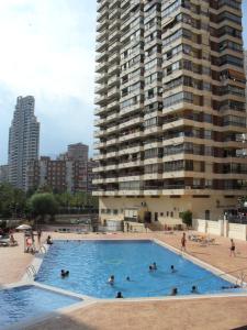 a large swimming pool in front of a tall building at Apartamentos Acuarium II in Benidorm