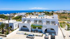 une maison blanche avec des voitures garées devant elle dans l'établissement Hotel Galini Sifnos, à Apollonia