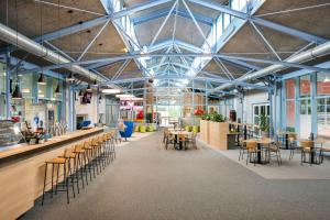 een grote kamer met tafels en stoelen en een bar bij JUFA Hotel Vulkanland in Gnas