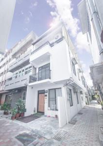 un edificio blanco con balcón en una calle en 聽故事台南民宿 有貓的民宿 en Tainan