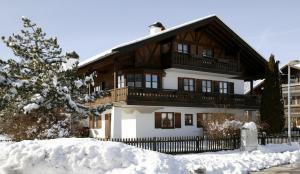 uma casa na neve com uma cerca em Ferienhaus Rosa 2 & 5 em Füssen