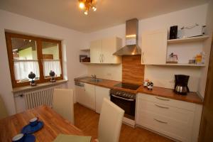 a kitchen with white cabinets and a wooden table at Ferienhaus Rosa 2 & 5 in Füssen
