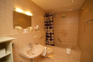 a bathroom with a sink and a toilet and a tub at Ferienhaus Rosa 2 & 5 in Füssen +11 photos