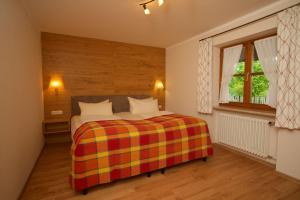 um quarto com uma cama com um cobertor colorido em Ferienhaus Rosa 2 & 5 em Füssen