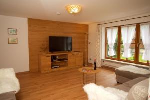 a living room with a flat screen tv on a wooden wall at Ferienhaus Rosa 2 & 5 in Füssen
