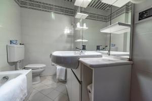 a bathroom with a sink and a toilet and a mirror at Hotel Pian Nava in Premeno +84 photos