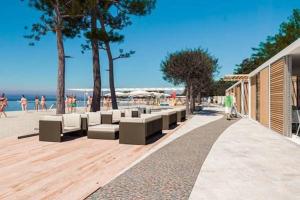 una playa con bancos y gente en la playa en Villa Amaris, en Brodarica