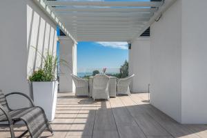 eine Terrasse mit Korbstühlen und Tischen auf einem Balkon in der Unterkunft Moje Orłowo Boutique Bed & Breakfast - Adults Only in Gdynia + 53 Fotos