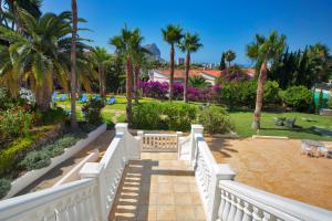 a white fence with palm trees and a park at Aparthotel Carrio Sol - Monty´s in Calpe