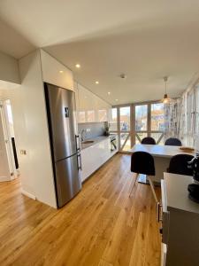 a kitchen with a stainless steel refrigerator in a room at Lagoon Attic Apartment Pervalka in Pervalka