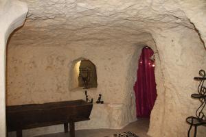 Zimmer mit einem Waschbecken in einer Steinwand in der Unterkunft Caves du coteau 1 in Lunay