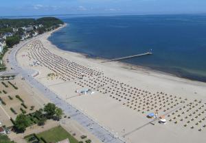 een luchtzicht op een strand met parasols en de oceaan bij Albatros in Travemünde