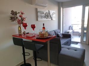 een woonkamer met een tafel met wijnglazen en een bank bij M & M Red Luxury in Paralia Katerinis
