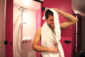 a man standing in a bathroom holding a towel at Smart Hyde Park Inn in London +7 photos