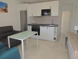 a living room with a table and a kitchen at Corbousier - Beach - Playa - Apartment 51 in Benalmádena