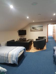 a hotel room with a bed and a tv and chairs at Reubens Loft for 1 to 6 person Family 4 miles outside Portrush in Bushmills