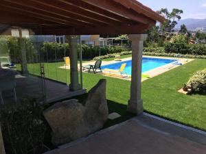 a backyard with a swimming pool and a large rock at Playa America! in Nigrán