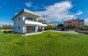 a house with a green lawn in front of it at Apart Residence Blue Sea in Poreč