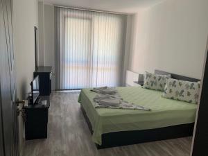 1 dormitorio con 1 cama, TV y ventana en Апартамент Трапезица en Veliko Tŭrnovo