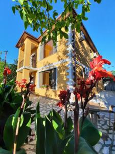 uma casa com flores vermelhas em frente em Hotel Alley em Martvili