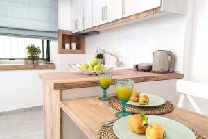 a kitchen with two plates of food and two glasses of orange juice at Elia Luxury Suite, Corfu Town in Corfu