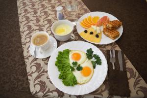 zwei Teller Eier und Gemüse auf dem Tisch in der Unterkunft Virginia Hotel in Joschkar-Ola