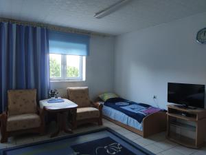 a small bedroom with a bed and a table and chairs at Hotel Kowalski in Mrągowo