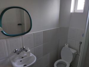 a bathroom with a mirror and a toilet and a sink at Hotel Kowalski in Mrągowo