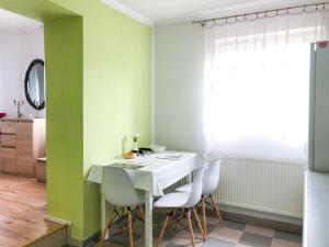 a dining room with a white table and white chairs at Hotel Kowalski in Mrągowo