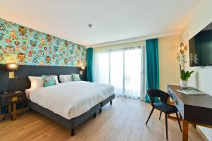 a hotel room with a bed and a desk and a desk at Hôtel La Villa Port d'Antibes & Spa in Antibes
