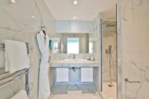 a white bathroom with a sink and a shower at Hôtel La Villa Port d'Antibes & Spa in Antibes