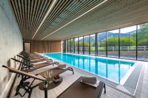 a large swimming pool with tables and chairs in a building at Tee House Čeladná in Čeladná