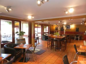 a restaurant with tables and chairs in a room at Logis Les Provinciales in Arpajon-sur-Cère