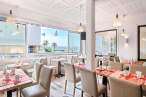 a restaurant with tables and chairs and large windows at Best Western Hôtel Royan Océan in Royan