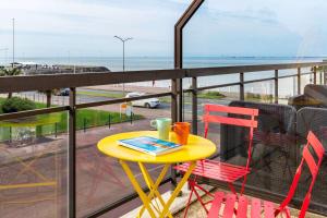 Best Western Hôtel Royan Océan في رويان: طاولة وكراسي على شرفة مطلة على الشاطئ