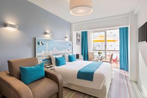 Pokój hotelowy z łóżkiem i krzesłem w obiekcie Best Western Hôtel Royan Océan w mieście Royan