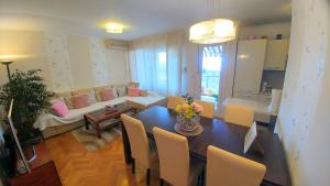 ein Esszimmer und ein Wohnzimmer mit einem Tisch und Stühlen in der Unterkunft Apartment Deluxe Sea View Split in Split