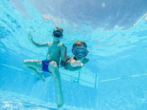 two people in the water in a swimming pool at Hotel Bolero in Biograd na Moru